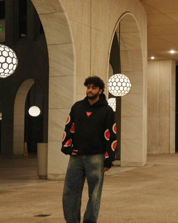 Person standing in a large, open architectural space with decorative lights and arches.